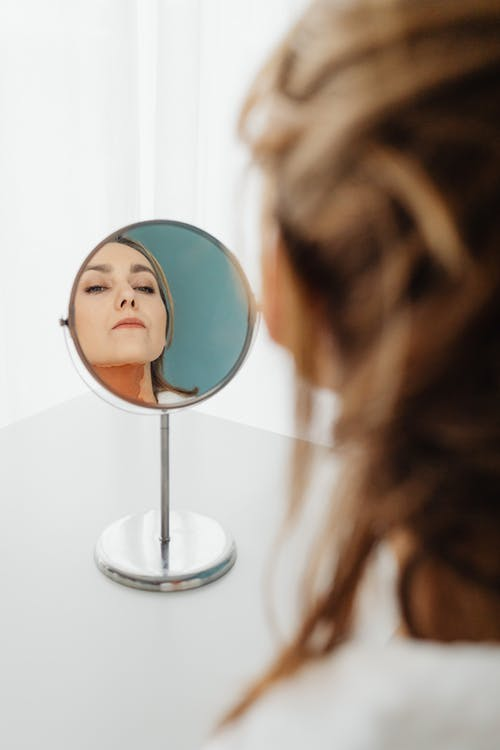  A person checking themselves in the mirror