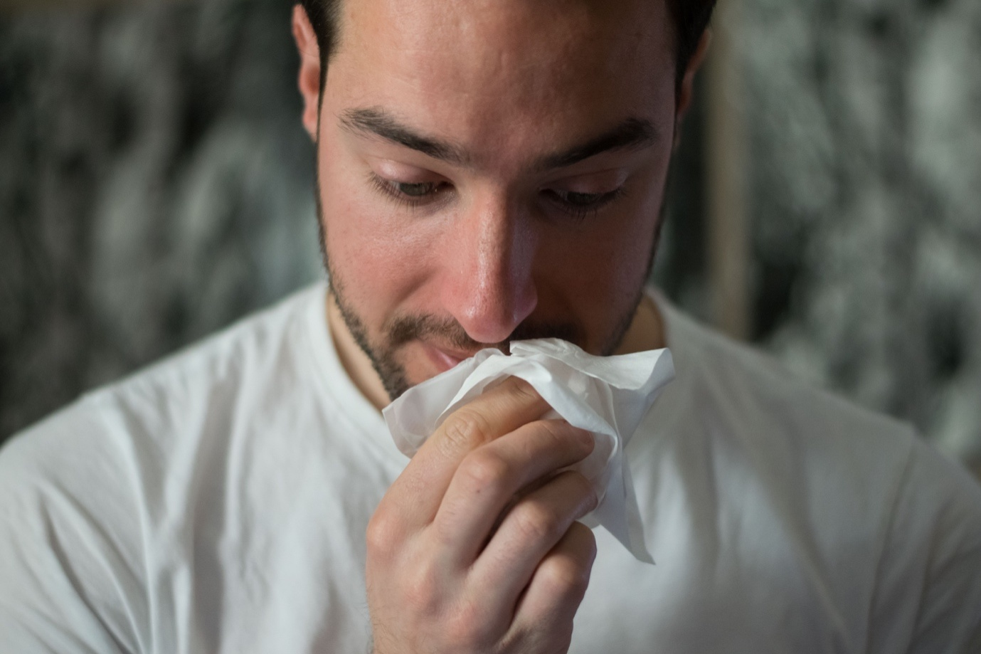 A person holding a tissue to their nose