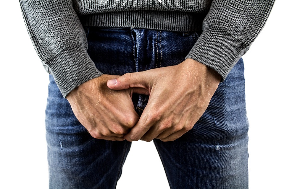 A man covering his genital area with his hands